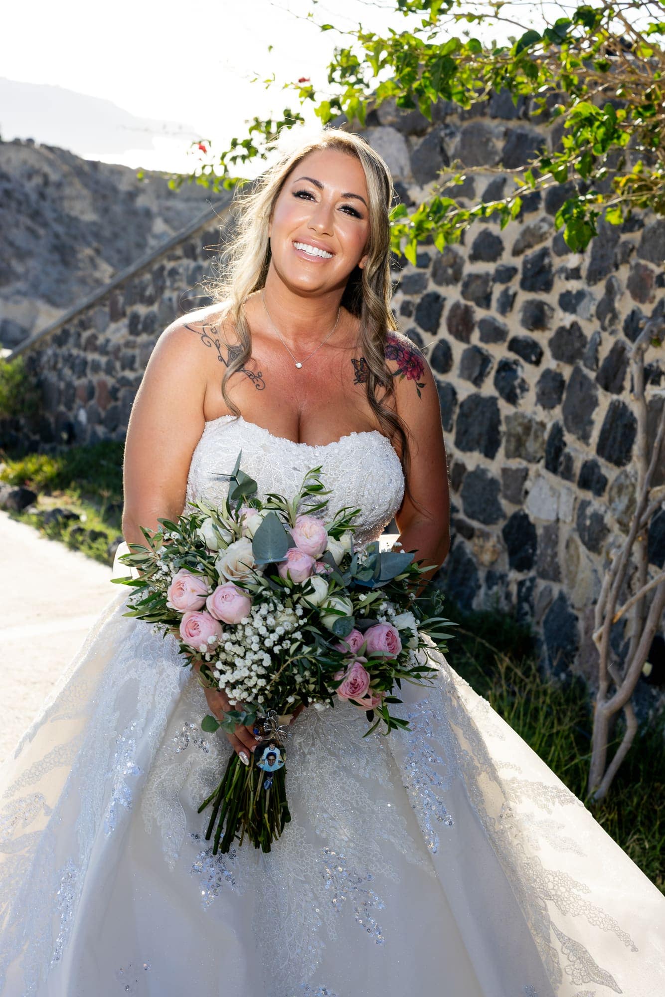 Mary & Chris — the ceremony beneath the crescent floral arch, Windmill venue on the caldera, Santorini