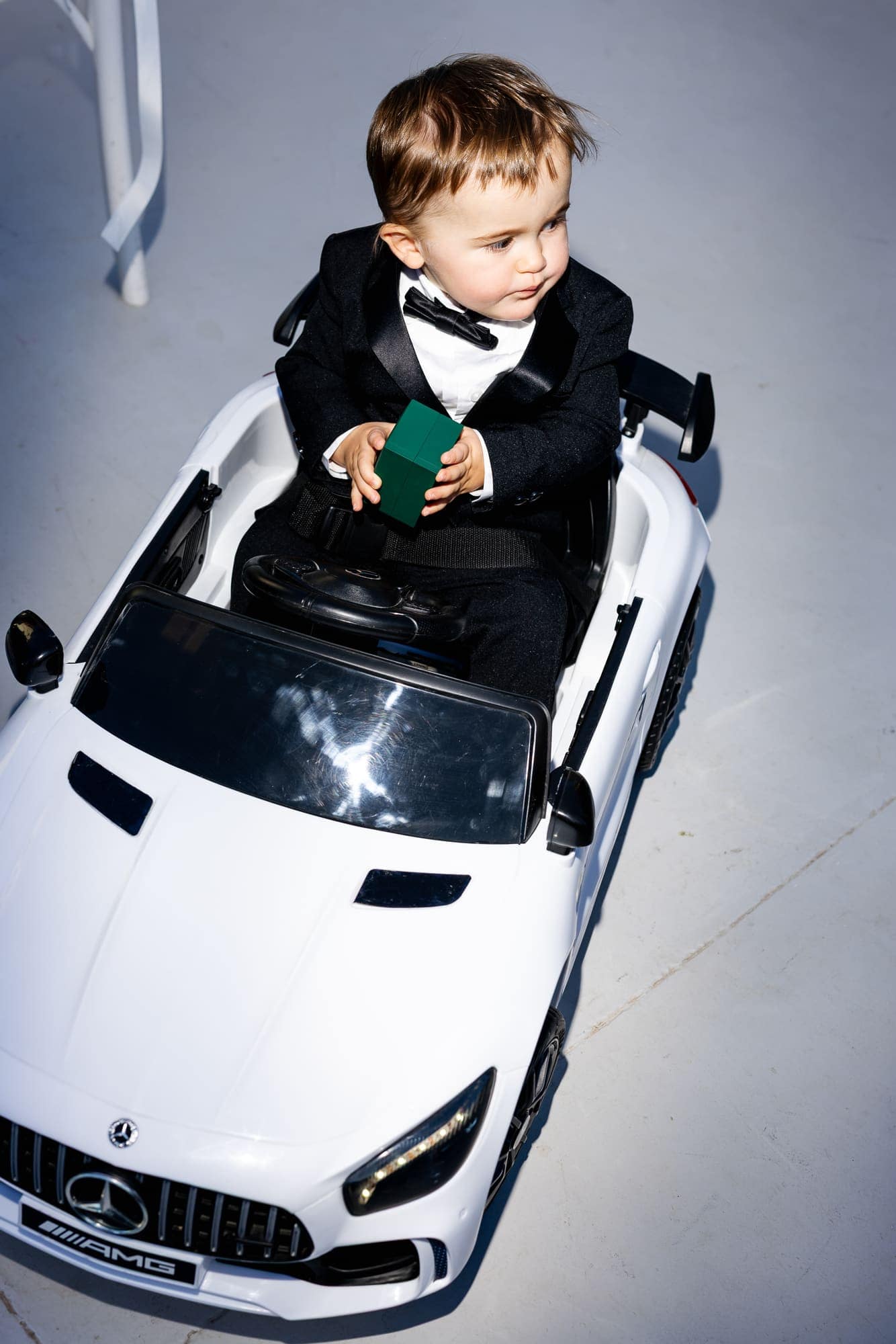 Mary & Chris — the ring bearer arriving in his own miniature convertible, Windmill venue on the caldera, Santorini