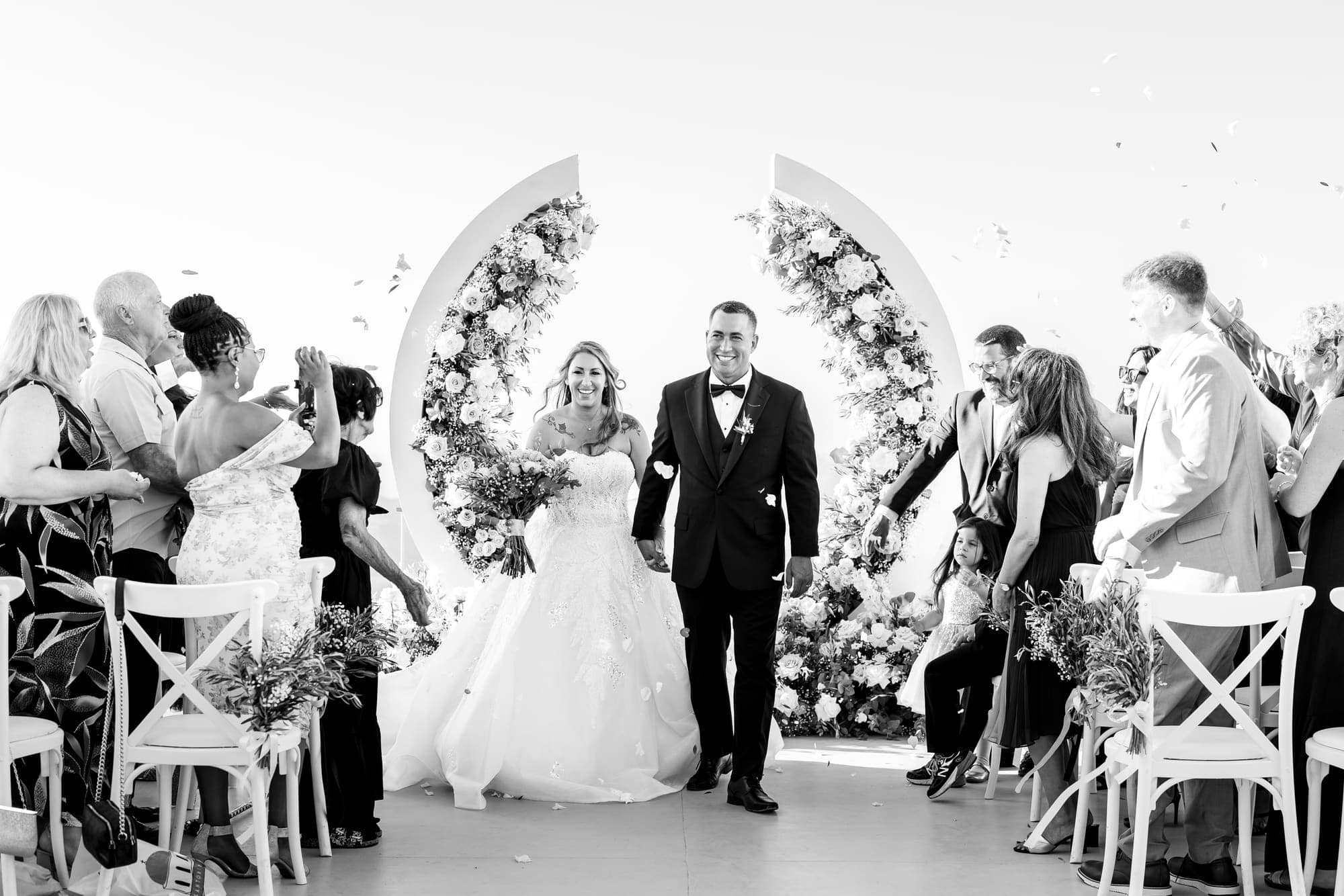 Mary & Chris — the recessional through a shower of confetti, Windmill venue on the caldera, Santorini