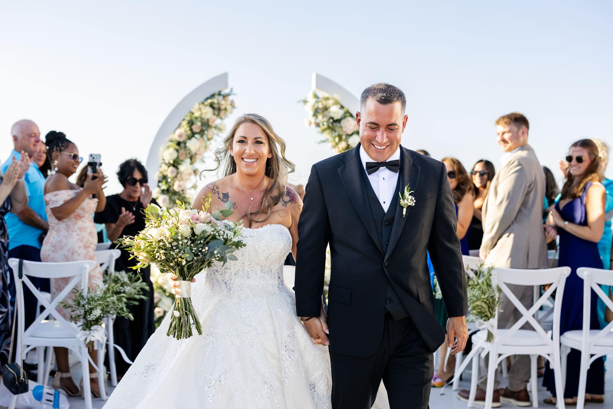 Mary & Chris — the recessional through a shower of confetti, Windmill venue on the caldera, Santorini