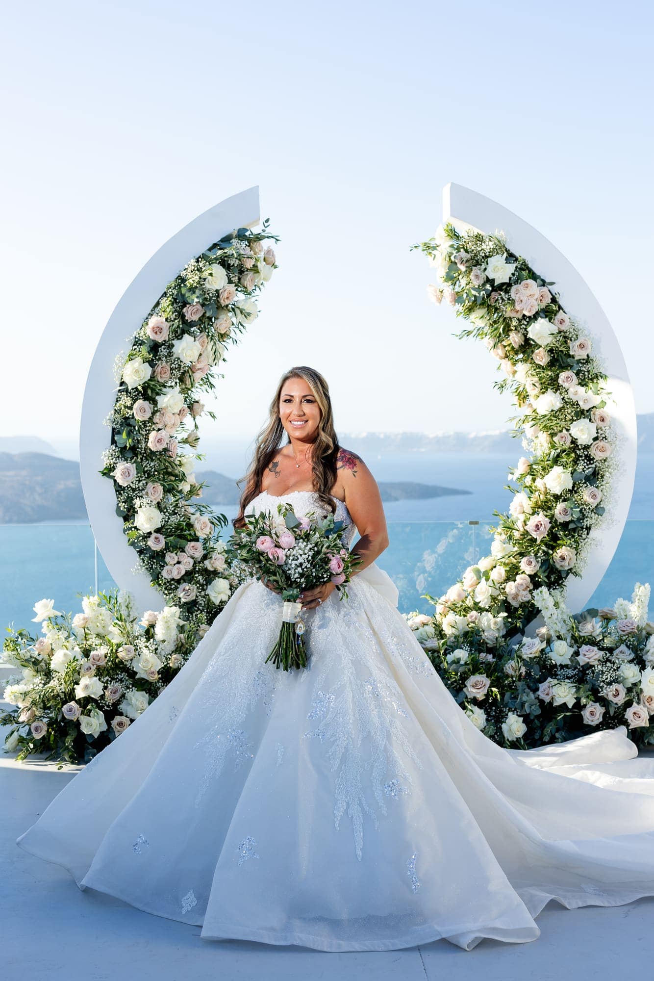 Mary & Chris — portraits at the crescent arch above the caldera, Windmill venue on the caldera, Santorini