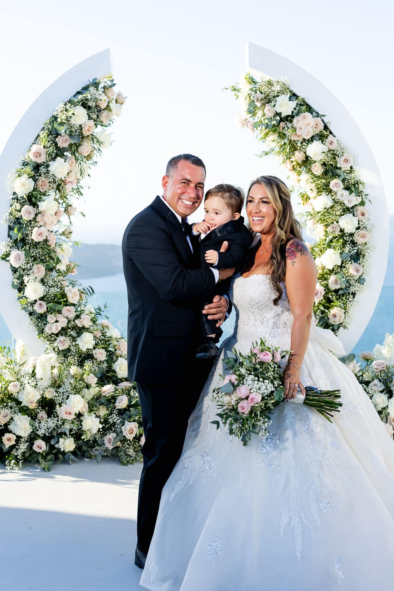 Mary & Chris — portraits at the crescent arch above the caldera, Windmill venue on the caldera, Santorini