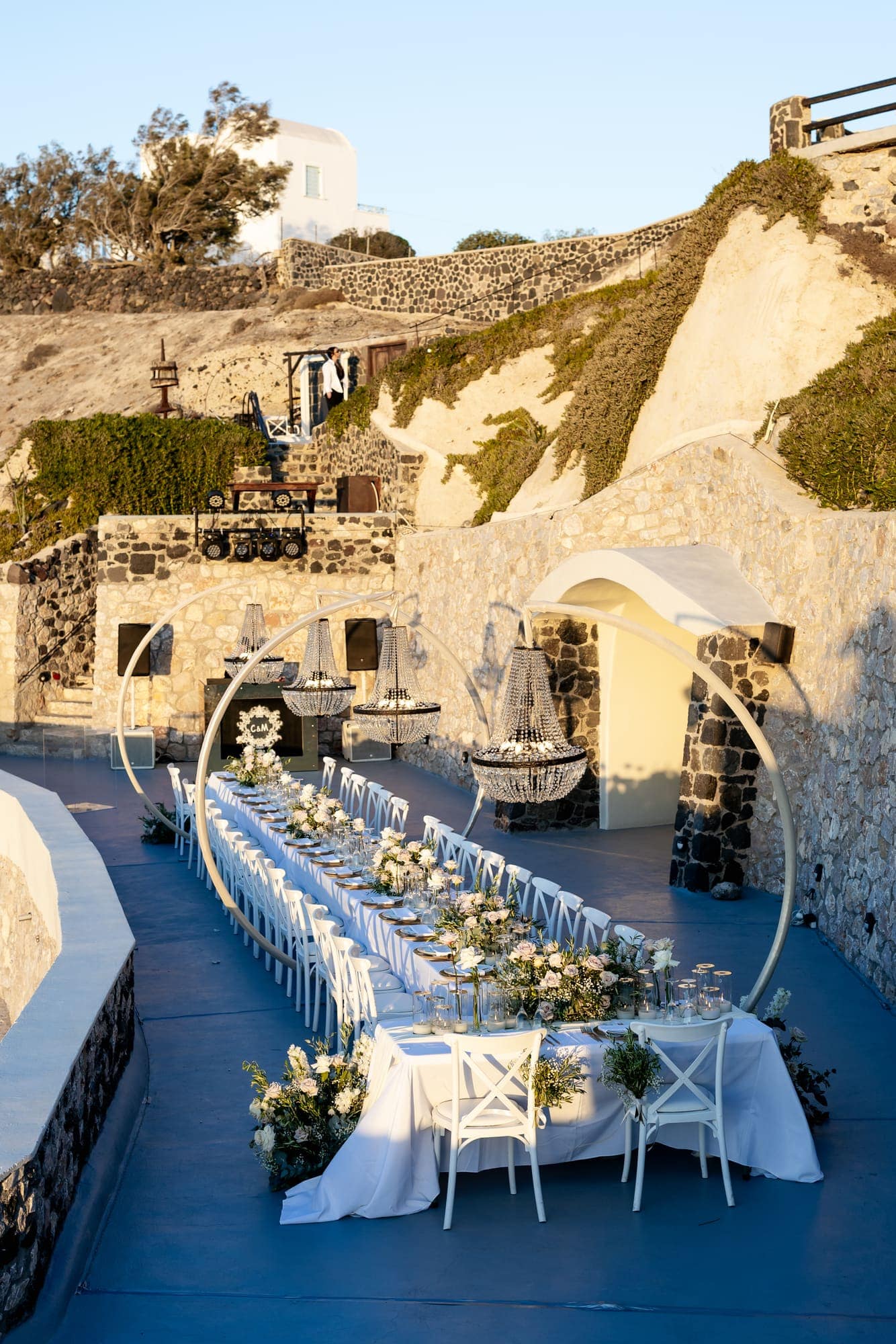 Mary & Chris — the dinner table set under crystal chandeliers, Windmill venue on the caldera, Santorini