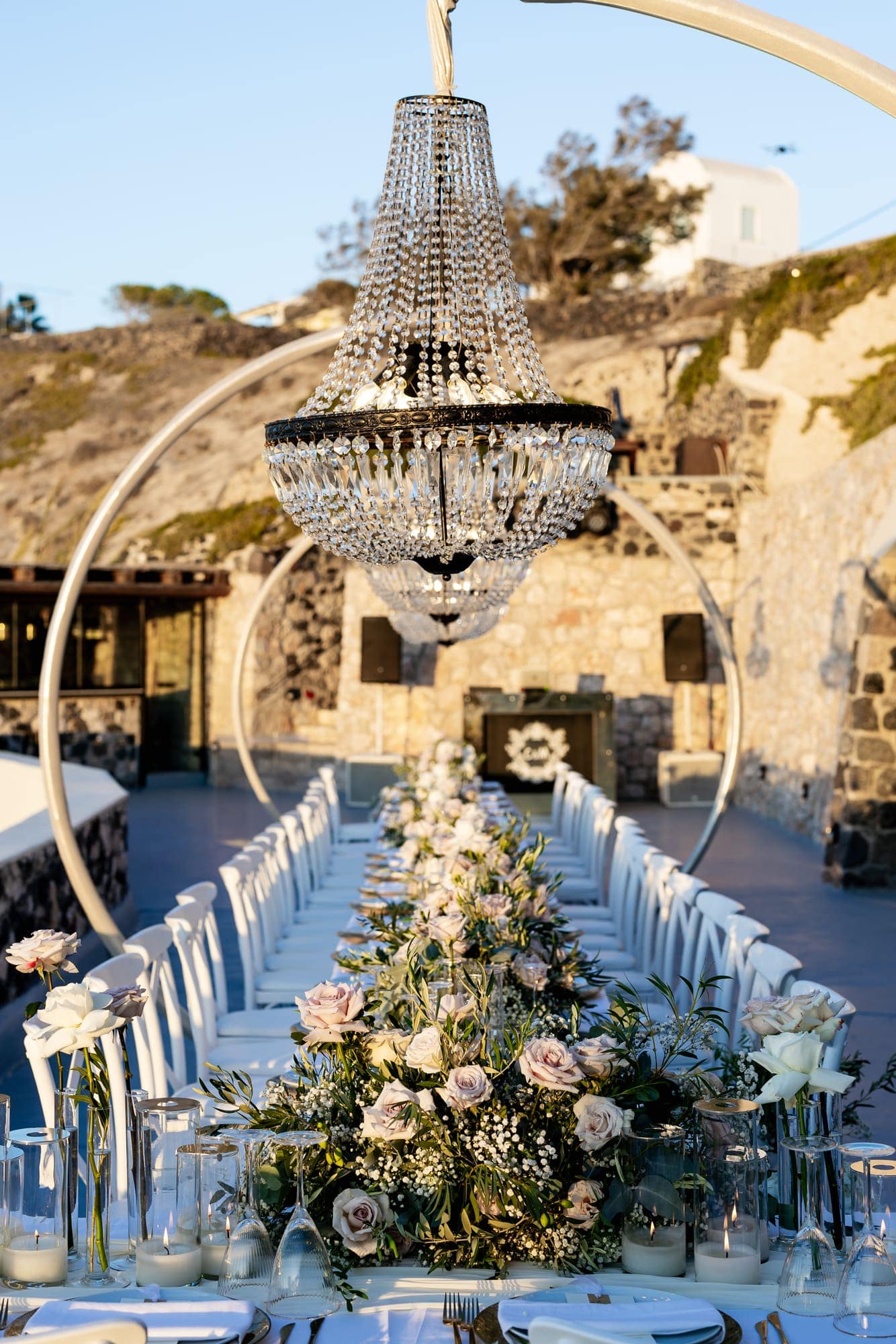 Mary & Chris — the dinner table set under crystal chandeliers, Windmill venue on the caldera, Santorini