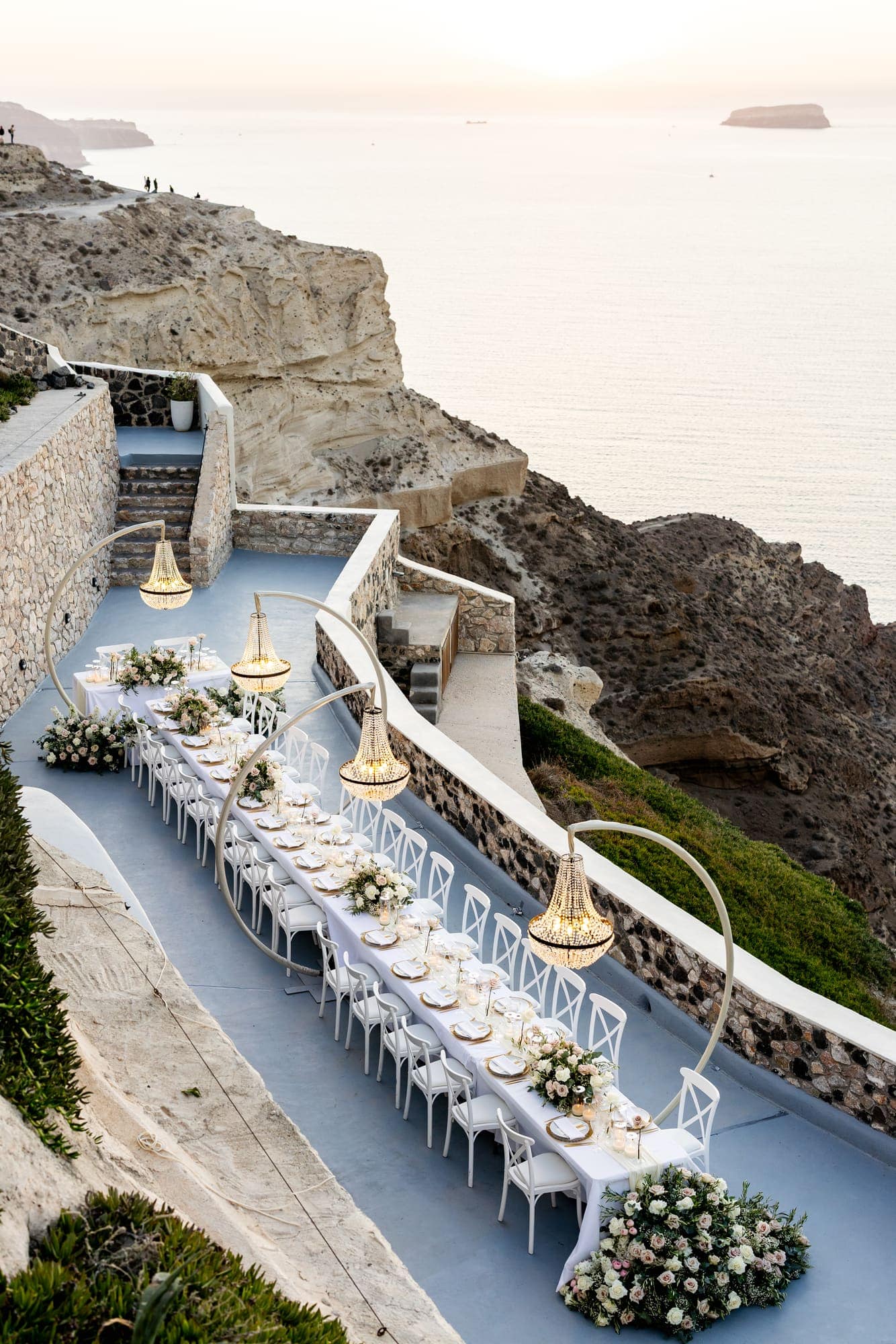 Mary & Chris — the dinner table set under crystal chandeliers, Windmill venue on the caldera, Santorini