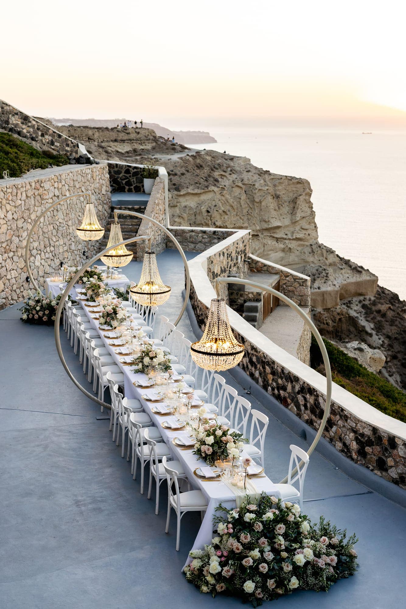 Mary & Chris — the dinner table set under crystal chandeliers, Windmill venue on the caldera, Santorini