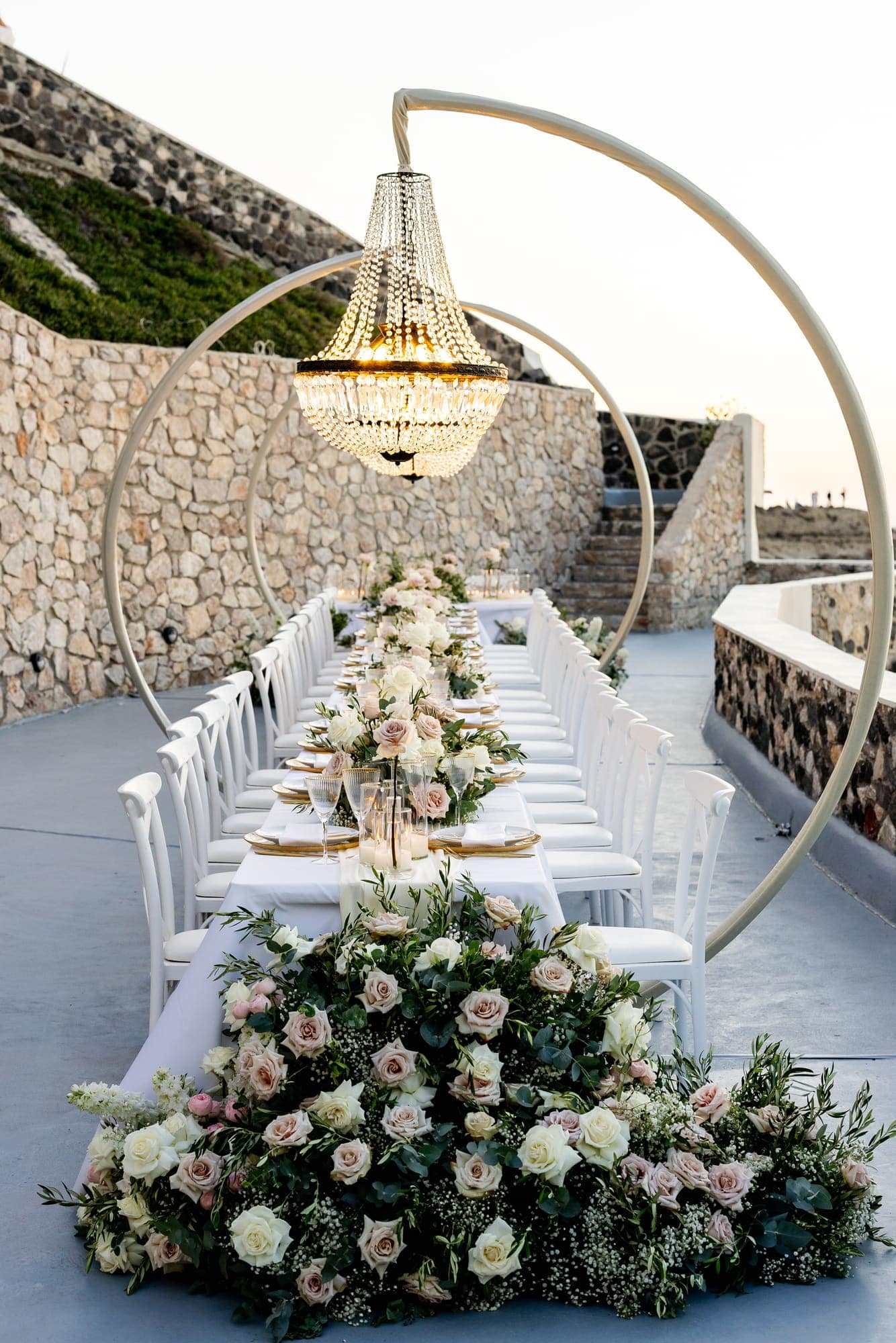Mary & Chris — the dinner table set under crystal chandeliers, Windmill venue on the caldera, Santorini