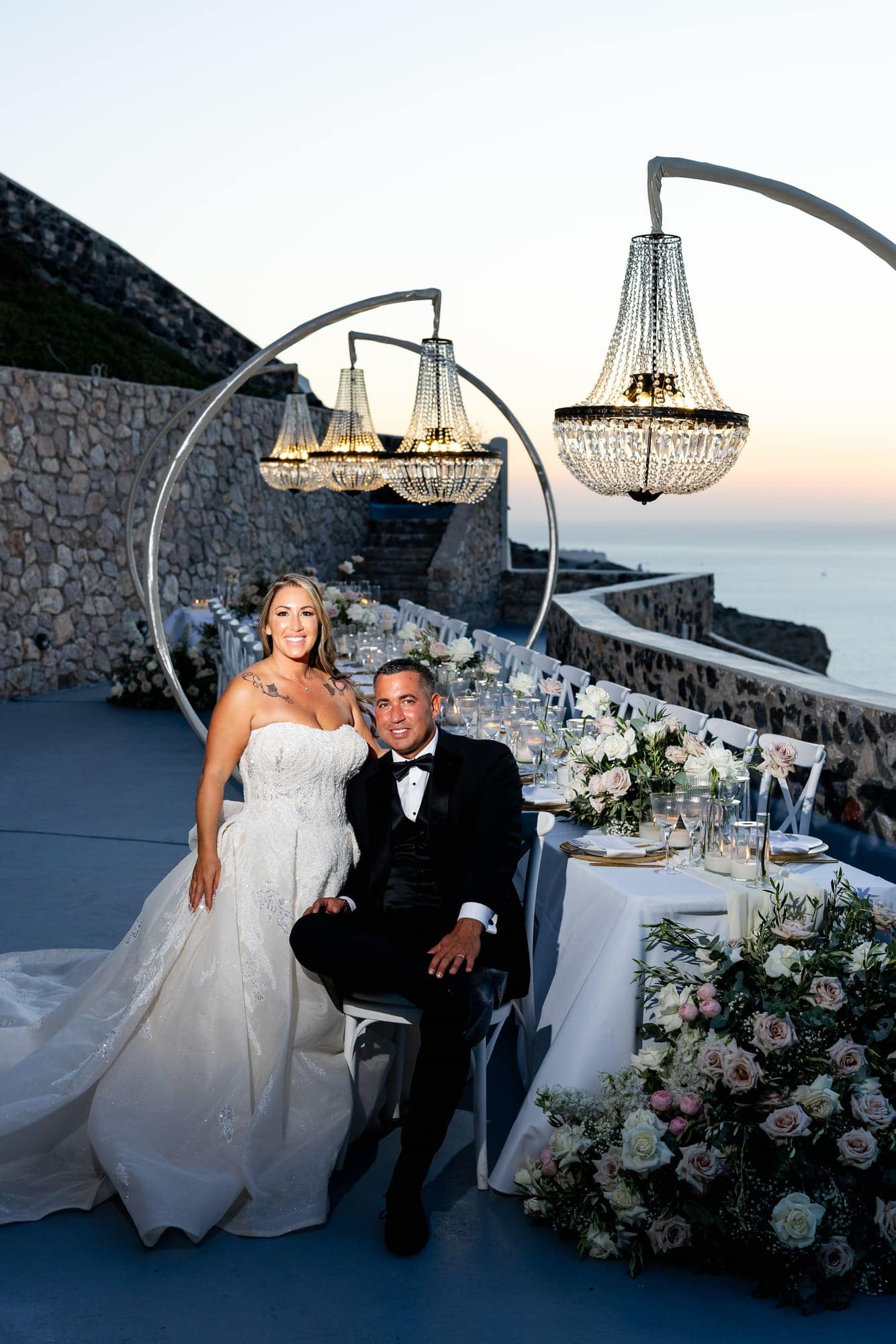 Mary & Chris — the dinner table set under crystal chandeliers, Windmill venue on the caldera, Santorini