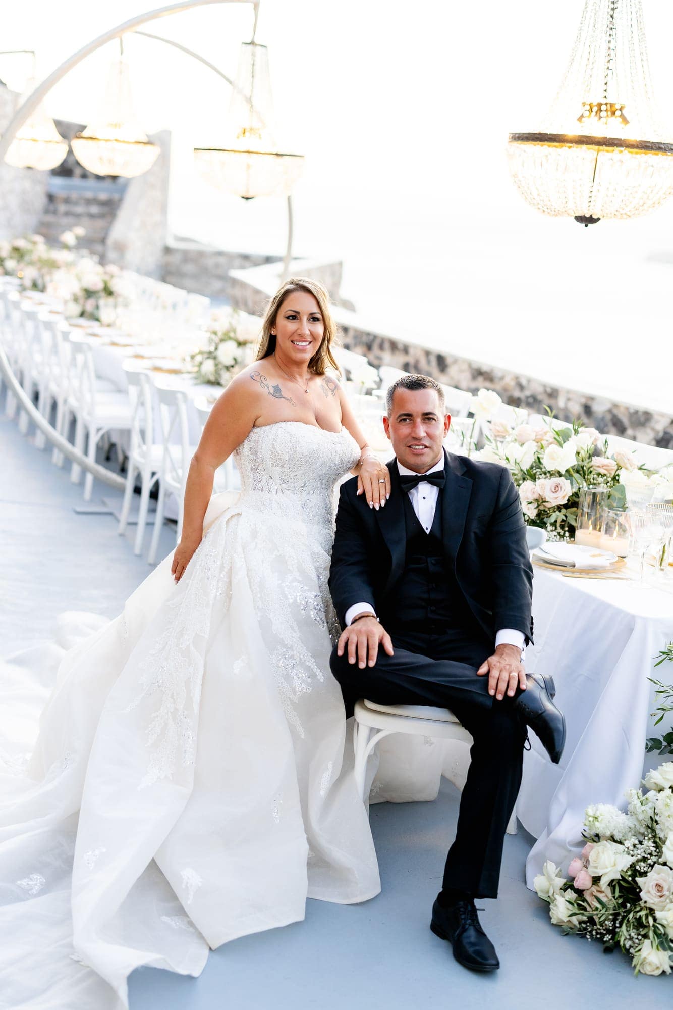 Mary & Chris — the dinner table set under crystal chandeliers, Windmill venue on the caldera, Santorini