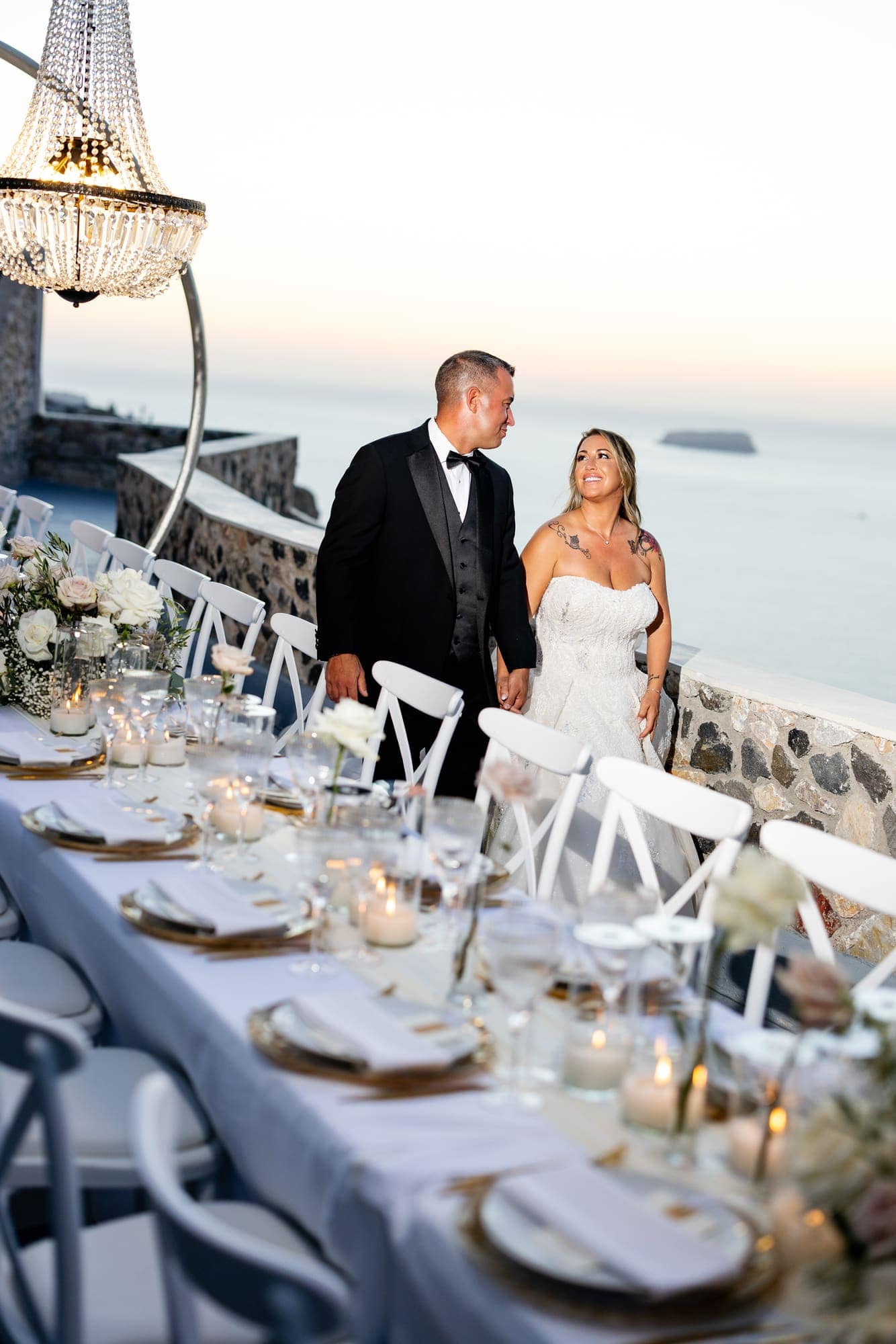 Mary & Chris — the dinner table set under crystal chandeliers, Windmill venue on the caldera, Santorini