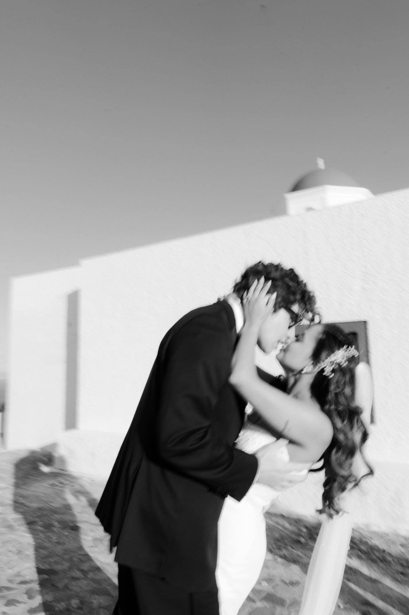 Tina & Kanon — portraits at a small blue-domed chapel, Cliffside terrace, Santorini