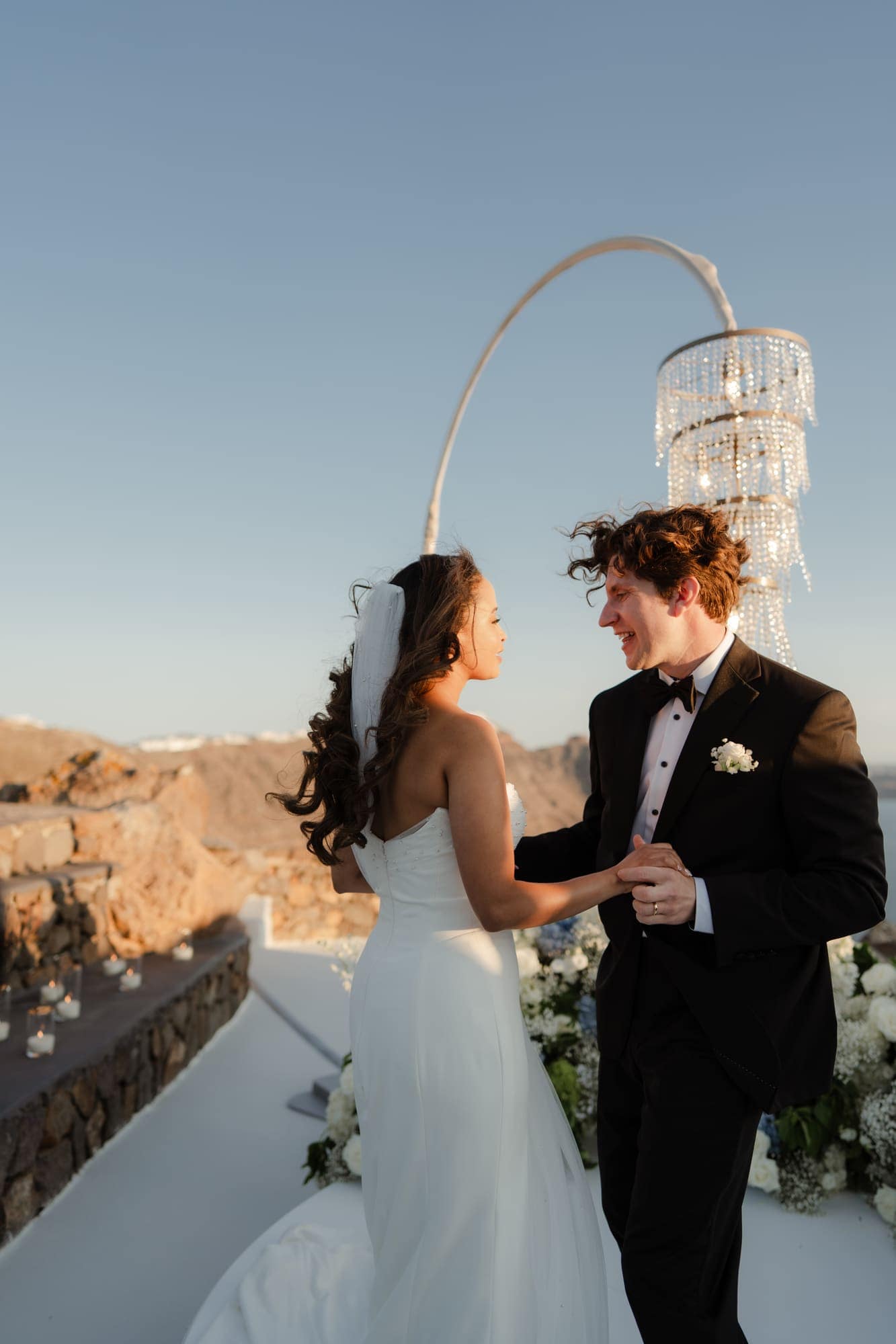 Tina & Kanon — the cake and the violin at sunset, Cliffside terrace, Santorini